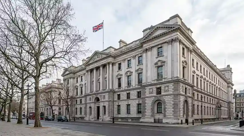The grand Portland stone facade of HM Treasury in Westminster on a clear winter morning